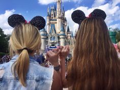 two girls standing in front of a castle