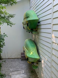 two green boats mounted to the side of a house