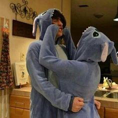 two people in pajamas hugging each other with one person wearing an elephant costume on their head