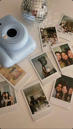 polaroid camera sitting on top of a table surrounded by photos