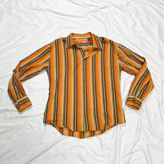 2000s long sleeve button up top. Stripe pattern. In good condition. Note: I try to match colors as much as possible to pictures but there is a possibility it won't be an exact match. Unless the color is completely incorrect I am unable to offer refunds for this reason. Size: XXL Brand is Enyce Clothing Company Measurements (taken on garment laid flat): Armpit to armpit: 25" Waist: 45" Shoulder to shoulder: 22" Armpit to hem: 17" Length (top of neck to bottom hem): 34.5" Fabric: 100% cotton 70s Clothing Png, Fitted Orange Long Sleeve Shirt, Fitted Long Sleeve Orange Shirt, Striped Long Sleeve Shirt For Fall, Orange Long Sleeve Top With Buttons, 90s Striped Long Sleeve Tops, Retro Orange Long Sleeve Shirt, Retro Orange Long Sleeve Blouse, Retro Long Sleeve Orange Blouse