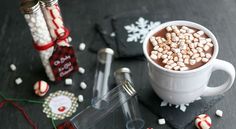 hot chocolate with marshmallows and candy canes on the table next to it