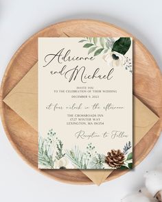 an elegant wedding card with greenery and pine cones