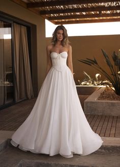 a woman in a white wedding dress standing on steps