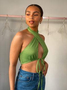 Elevate your style with the captivating Suki Green Halter Neck Crop Top. This stunning addition to your wardrobe is designed to make a statement and turn heads wherever you go. Crafted from a luxurious micro speckle green fabric, this crop top boasts a halter neck design that exudes elegance and sophistication. The open bust and tie front add a touch of allure, while the low back detail creates a unique and stylish look that is sure to impress. Not only does the Suki Green Halter Neck Crop Top o Green Fitted Halter Top For Party, Fitted Cropped Halter Top For Party, Green Sleeveless Halter Top For Party, Versatile Halter Neck Party Top, Green Summer Party Tops, Spring Halter Crop Top For Night Out, Spring Crop Top Halter For Night Out, Trendy Cropped Party Tops, Green Stretch Halter Neck Top