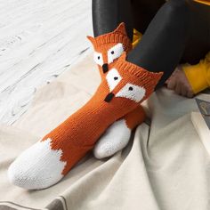 a person sitting on the floor with their legs crossed and wearing socks that have foxes on them