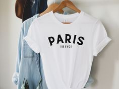 Paris T-shirt made for both men and women.  This soft cotton short sleeve tee is pure comfort and features the words, "Paris France".  It is perfect for travel, trekking across campus, lounging at home, and up-styling for brunch! This T-shirt also makes for the perfect gift! **SIZING** This T-shirt comes in various sizes from Small to 3XL. Please be sure to refer to the sizing chart in the photos.  Order up 1-2 sizes for the oversized look perfect with leggings.  **COMFORT** This classic unisex Paris Tshirt, Euro Chic, France Vacation, Paris Gifts, City Outfit, Paris Shirt, Paris Trip, Paris T Shirt, Travel Shirt