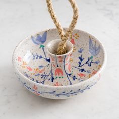 a bowl with rope tied to it sitting on a white counter top next to another bowl