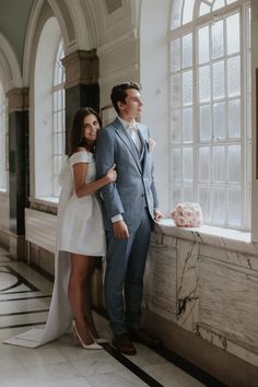 a man and woman standing next to each other near a window