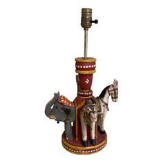 an old fashioned lamp with two horses on it's base and a horse figurine next to it