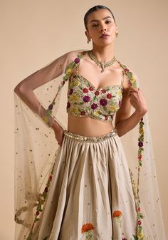 Elevate your ethnic wardrobe with Ivory Embroidered Lehenga. Crafted from luxurious silk, the lehenga features intricate thread, sequin, and cutdana embroidery in stunning floral patterns. Teamed with a modern cut embroidered strappy blouse and a beautifully adorned dupatta. This ensemble is ideal for a bride or bride-to-be, ensuring an unforgettable, elegant look for your special day. Composition : Skirt & Blouse - Silk, Dupatta - Net Care: Dry Clean Only and Vacuum Storage This product can be customized for sleeves, length and colour Delivery : 4-6 weeks as the product is hand crafted. Check Size Guide or choose MySize for free customisation (All Sizes above XL can be made at 15% additional cost) For more information and sizes please contact fabiliciousfashion@gmail.com or visit our Cope Silk Sets With Multicolor Embroidery For Wedding, Cream Sets With Resham Embroidery For Reception, Cream Bollywood Lehenga With Floral Embroidery, Traditional Drape Sets With Floral Embroidery In Cream, Cream Sets With Floral Embroidery And Traditional Drape, Designer Tissue Silk Lehenga With Floral Embroidery, Reception Silk Set With Multicolor Embroidery, Designer Cream Raw Silk Choli, Festive Tissue Silk Lehenga With Floral Embroidery