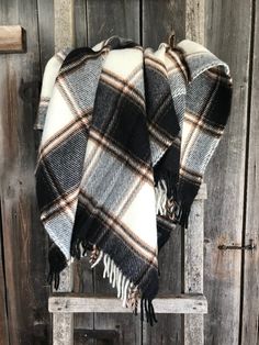 a black and white plaid blanket sitting on top of a wooden chair