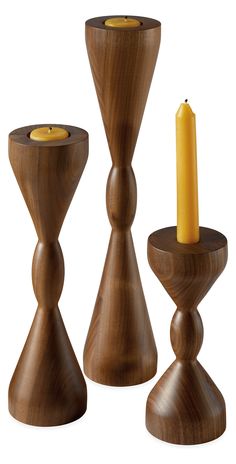 three wooden candlesticks with one candle in the middle and two on each side