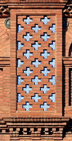 an old brick building with blue and white tiles on the window sill in front of it