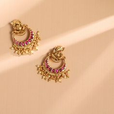 Description Spark your traditional style with these beautiful silver earrings from Paksha. Featuring a nakshi Lord Ganesha motif on the stud with a Kempu studded Chaandbali drop. This pair is finished with gold-tone plating and little gold ball drops. Wear yours with other nakshi jewelry – these are true favorites. Product Information Materials used: 925 Silver with 1.0-microns Antique Gold Plating Stones: Semi precious stones Length: 4 cm Findings: Hook & links 22k Gold Bollywood Chandbalis, Navratri Chandbalis With Intricate Design, Traditional Yellow Gold Chandbalis For Festive Occasions, Traditional Yellow Gold Cutdana Danglers, Traditional Yellow Gold Danglers With Cutdana, Silver Kundan Earrings For Puja, 22k Gold Chandbali Jewelry For Diwali, 22k Gold Temple Jewelry Chandbalis For Diwali, Temple Jewelry Yellow Gold Chandbalis