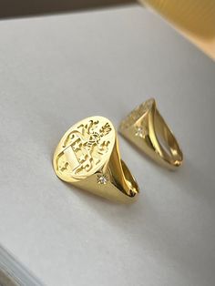 "gold family crest signet ring delicately engraved with your family crest, any other image or initials you want ♡ the stones are cubic zirconia the ring has solid back. deep and detailed engraving very delicately handcrafted unisex - looks super cool on both women & men additional inside engravings cost 12 USD. please contact us if you request inside engravins or simply go back to our shop and purchase the \"Side or inside engraving fee\" listing. this gold family creat signet ring is available Family Crest Rings Men, Old Money Signet Ring, Gold Oval Signet Ring With Coat Of Arms, Formal Yellow Gold Signet Ring With Coat Of Arms, Heirloom Oval Signet Ring With Coat Of Arms, Formal Yellow Gold Engraved Ring With Coat Of Arms, Luxury Yellow Gold Signet Ring With Coat Of Arms, Luxury Yellow Gold Coat Of Arms Signet Ring, Luxury Signet Ring With Coat Of Arms For Anniversary