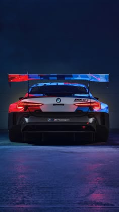 the rear end of a bmw sports car with red and blue lights on it's roof