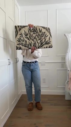 a woman holding up a piece of fabric with leaves on it