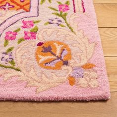 a close up of a rug on a wooden floor with wood floors and pink carpet