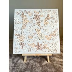 a wooden easel with an intricately designed design on the top and bottom, sitting on a carpeted surface