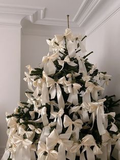 a decorated christmas tree with white bows