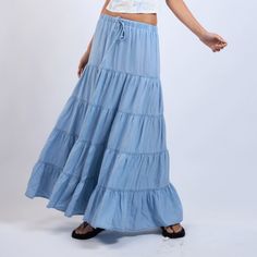 The Denim Days Maxi Skirt features a lightweight denim fabric and tiered ruffle design. Perfect for year-round wear and has an drawstring waistband for all-day comfort Material & Care: Made from 100% Tencel. For best care, machine wash cold with like colors on a gentle cycle. Use a mild detergent. Avoid bleach. Hang to dry. Iron on low heat if needed Size & Fit: Model is 5'8" wearing size small Bust: 34B Waist: 24 Hips: 34 Blue Drawstring Skirt For Spring, Spring Blue Drawstring Skirt, Beach Cotton Skirt With Drawstring, Vacation Tiered Skirt With Drawstring, Cotton Medium Wash Ruffled Skirt, Medium Wash Cotton Skirt With Ruffles, Denim Blue Ruffled Cotton Skirt, Summer Cotton Denim Skirt With Ruffles, Denim Blue Cotton Ruffled Skirt