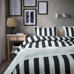 black and white striped bedding with pictures on the wall