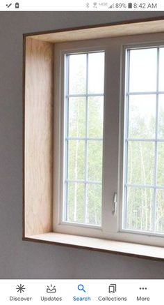 an open window in the corner of a room that is being painted gray and white