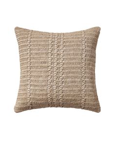 a beige knitted pillow on a white background