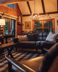 a living room filled with furniture and a chandelier hanging from the ceiling above