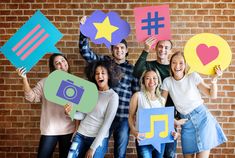 a group of people holding up paper cutouts