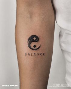 a person with a tattoo on their arm that reads balance and the word balance is written in black ink