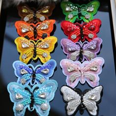 four different colored bows with sequins on them sitting in a display case together