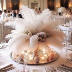 the centerpiece is decorated with white feathers and candles for an elegant touch to the table