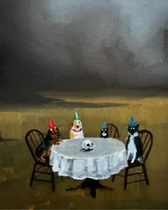 three dogs are sitting at a table with birthday hats on and one dog is wearing a party hat