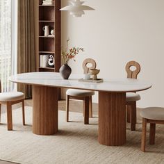 a dining room table with chairs and a vase on the table in front of it