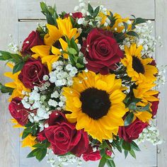 a bouquet of sunflowers and roses on a table