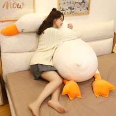 a woman laying on top of a bed next to an inflatable duck pillow