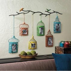 there is a birdcage hanging on the wall with pictures and birds in it