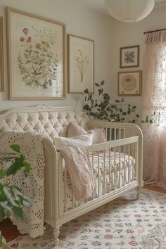 a white crib in a room with pictures on the wall and plants behind it