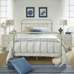 a white bed sitting in a bedroom on top of a blue and white striped rug