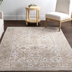 a living room area with two chairs and a rug on the floor in front of a white couch