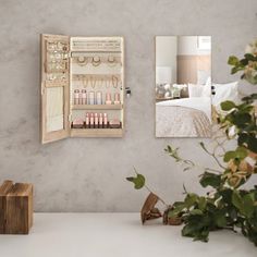 a mirror that is on the side of a wall next to a vase with flowers