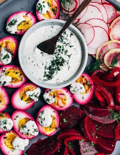 deviled eggs with yogurt and radishes on a platter