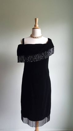 This stunning vintage black silk-velvet dress features a sumptuous foldover, off-shoulder neckline; a heavily beaded, always-in-motion fringe at the shoulders and hemline; and is fully lined in black satin. A winter-party must. Size small. Era: 1980s 60s Cocktail Dress, Silk Velvet Dress, Deco Beads, Fringe Shawl, Long Black Coat, Dress Off Shoulder, Winter Party, Evening Formal, Beaded Fringe