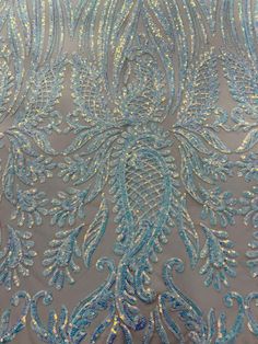 blue and silver beaded fabric with large, intricate design on the back of it