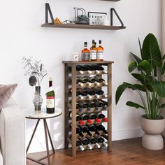 a living room with two shelves filled with bottles of wine next to a white couch