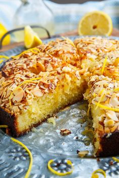 there is a cake that has been cut in half on a plate with lemons around it