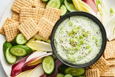 a plate with crackers, cucumbers and celery