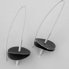 pair of black and silver earrings sitting on top of each other